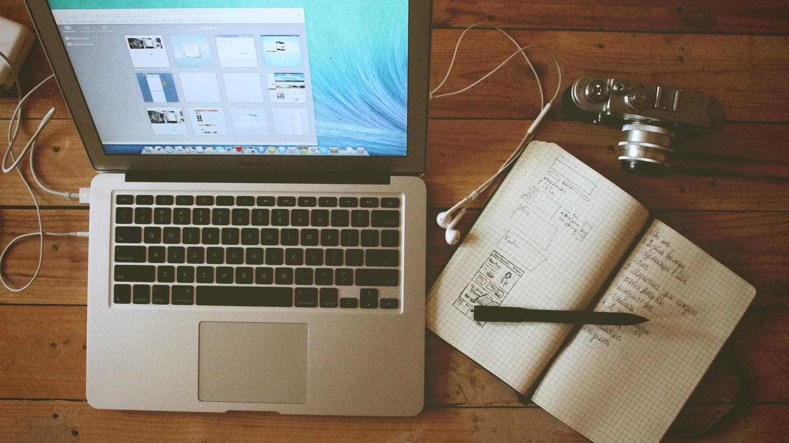 A laptop and notebook on a desk